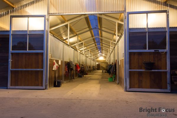 beleuchtete Pferdeboxen auf Hof Eichkamp bei Nacht